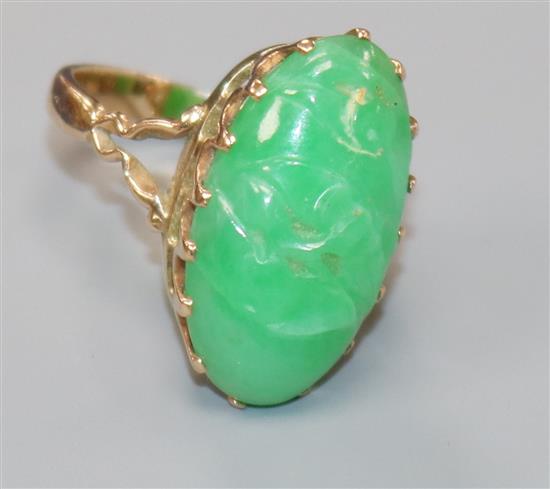 A 9ct gold and carved jadeite oval ring, size M.